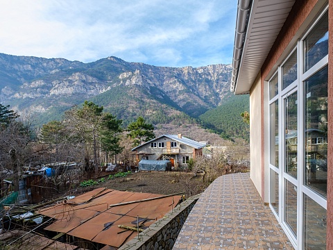 Двухэтажный коттедж с панорамным остеклением и видом на лес и горы 